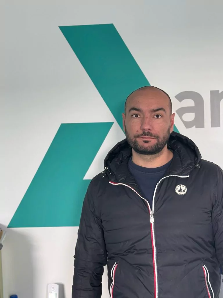 Loïc, dirigeant d'Ambetao, devant le logo de l'entreprise