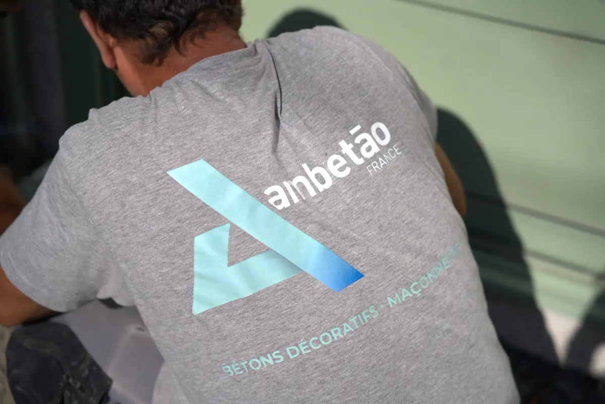 Un membre de l'équipe d'Ambetao, de dos, au travail sur un chantier, avec le logo Ambetao sur son tee-shirt